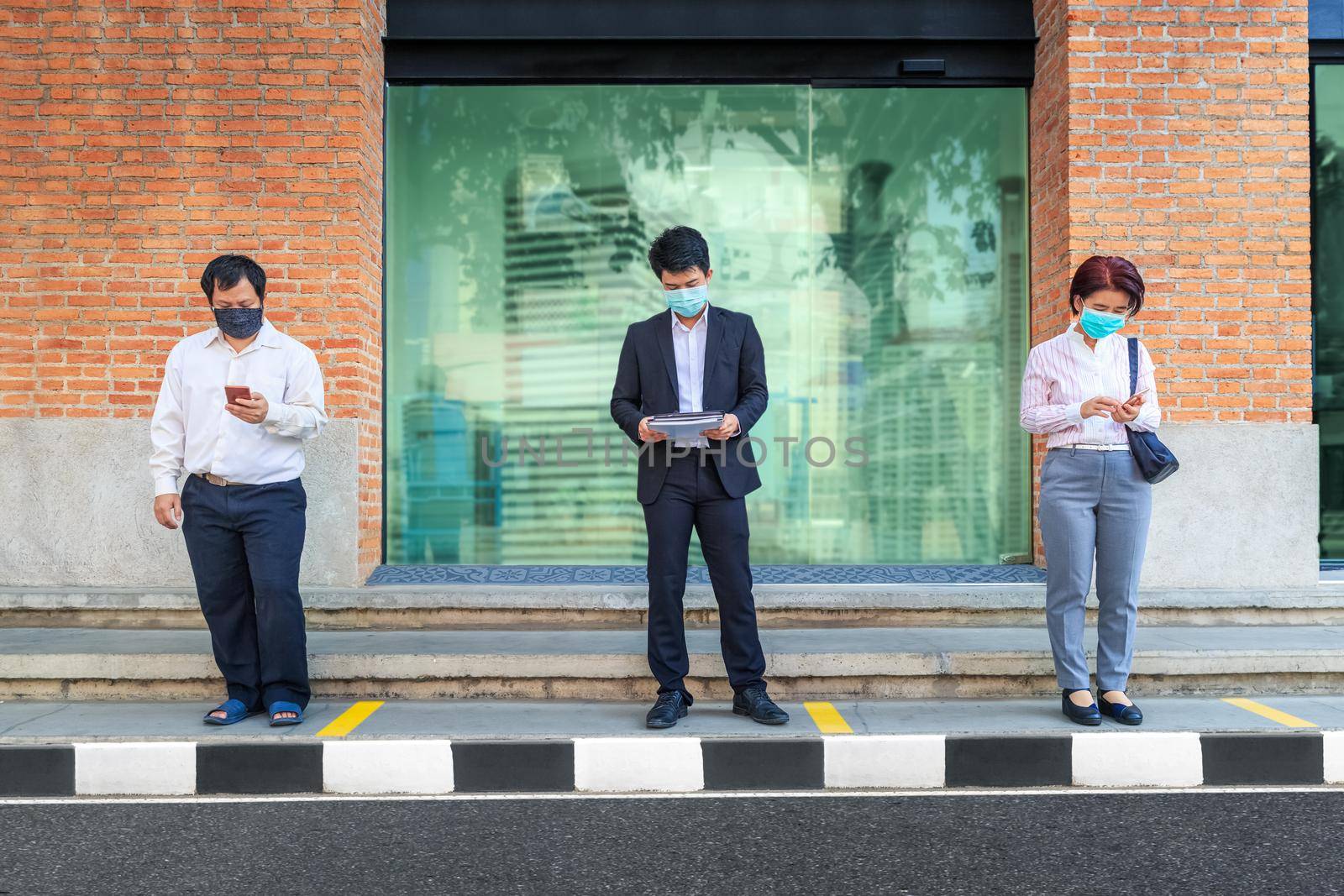 Asian middle aged people wearing mask and keep social distancing to avoid the spread of COVID-19