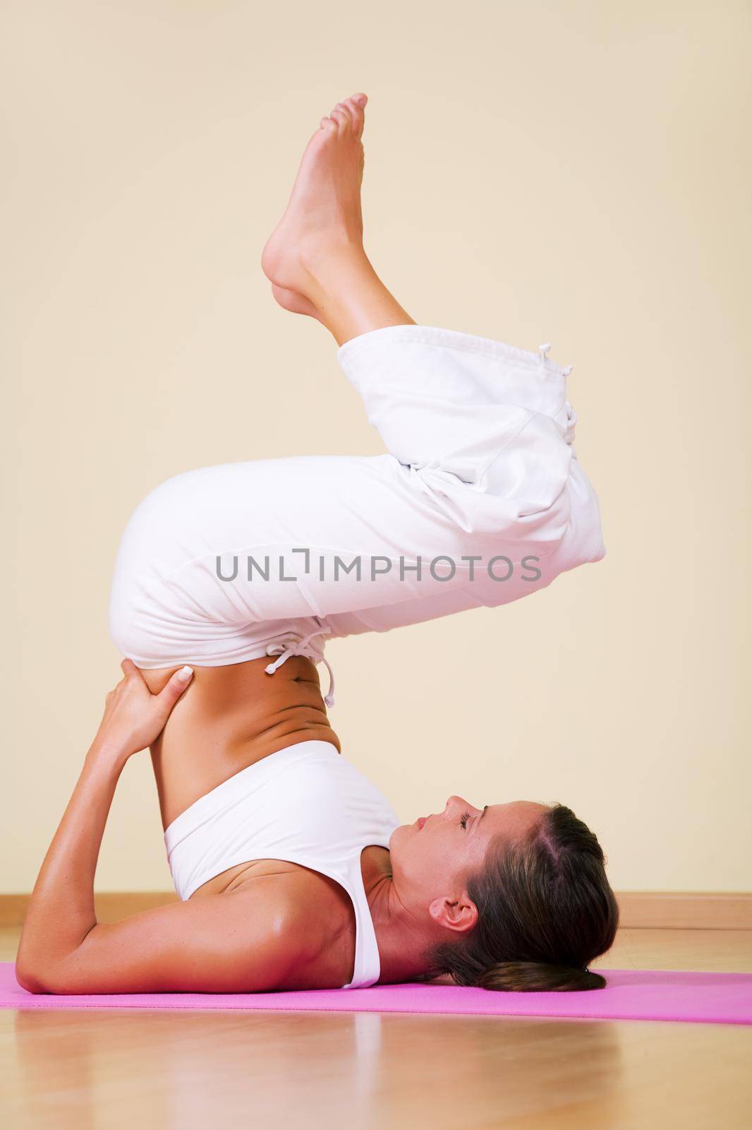 Young woman in a yoga position (Ardha Sarvangasana)