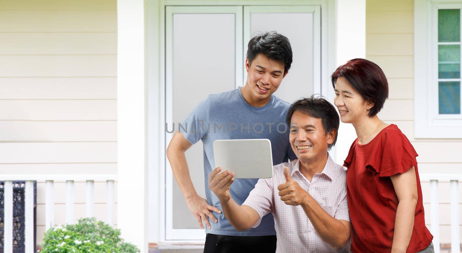 Happy family leisure time and watching at the tablet together in backyard by toa55