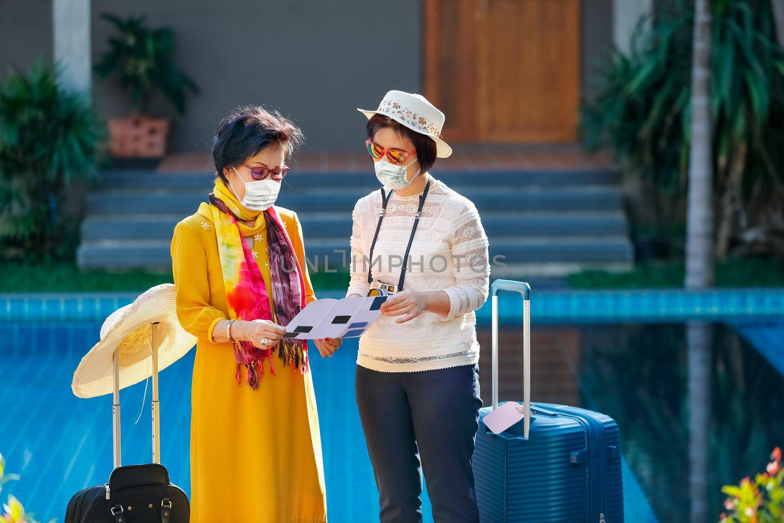 senior woman tourist with daughter wearing face masks to prevent covid-19