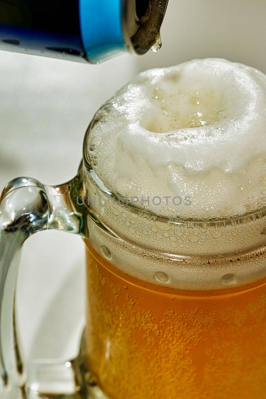 Beer is poured from a tin can into a transparent glass goblet by vizland