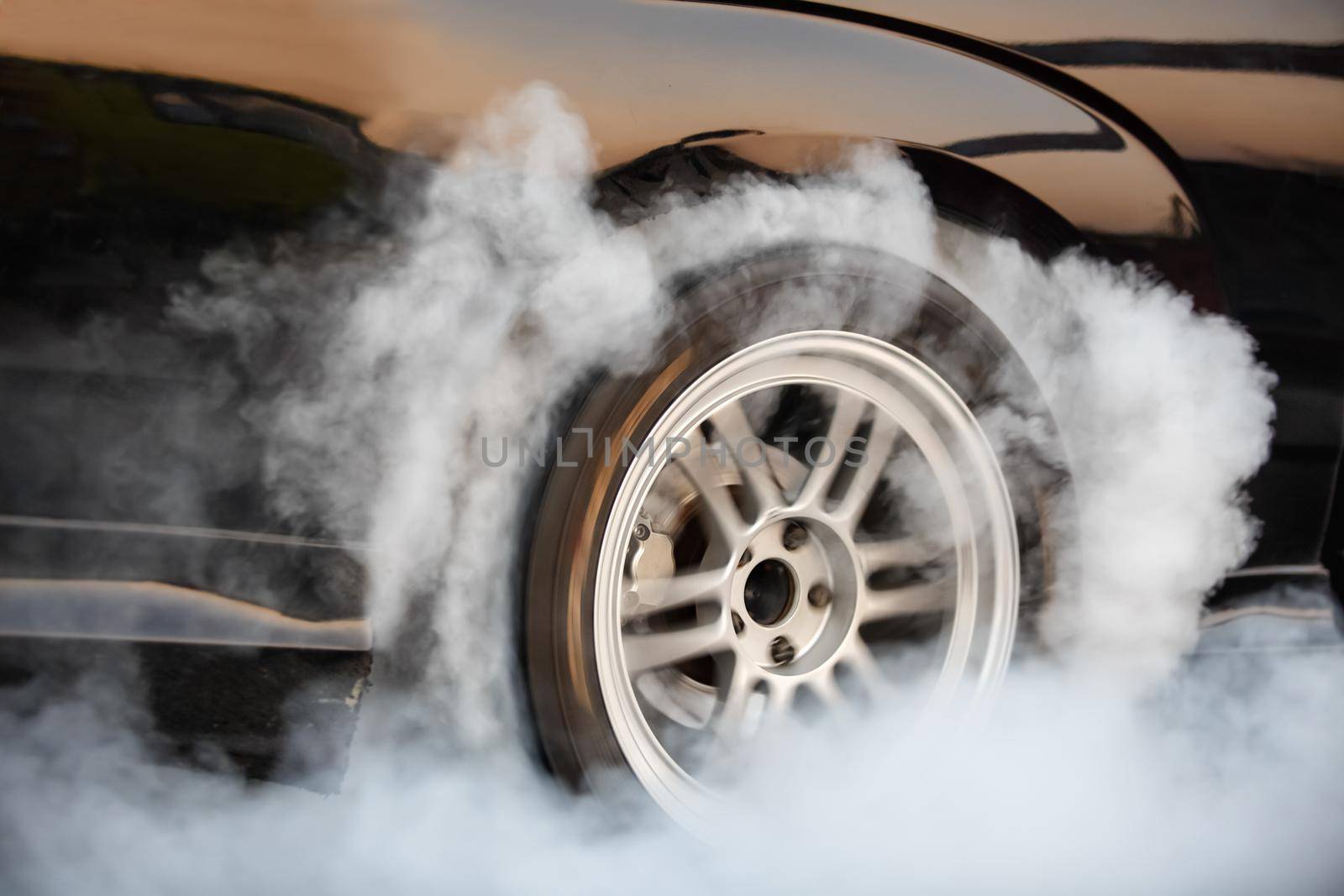 Drag racing car burns rubber off its tires in preparation for the race