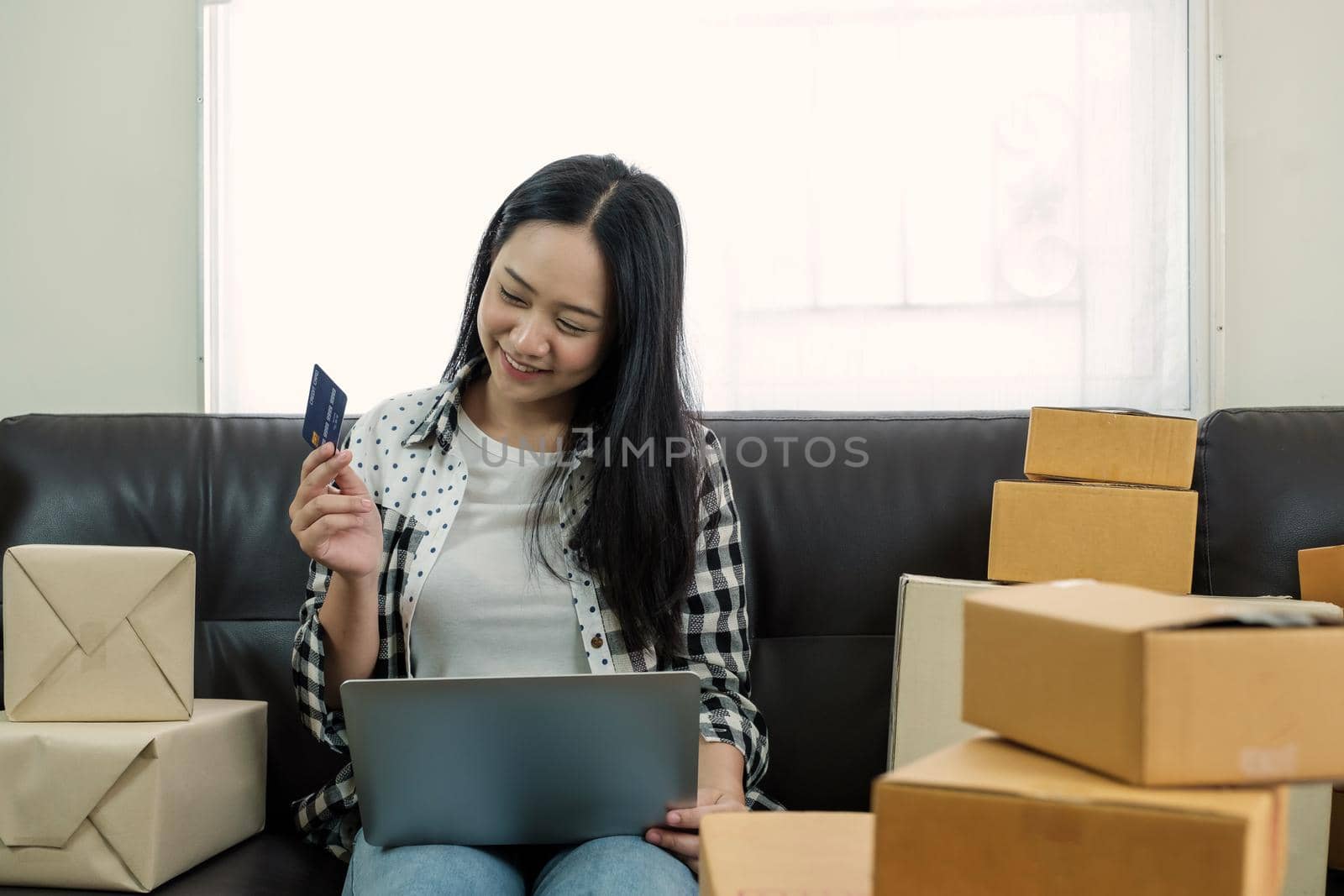 Young beautiful woman using laptop computer for online shopping with credit card at her home.