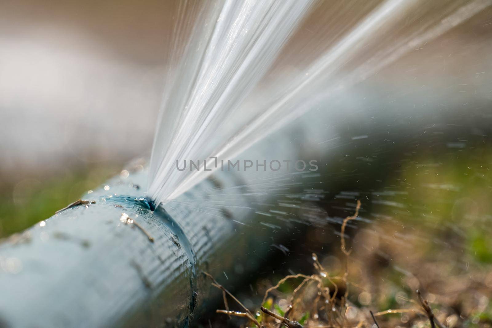 water leaking from hole in a agriculture hose.