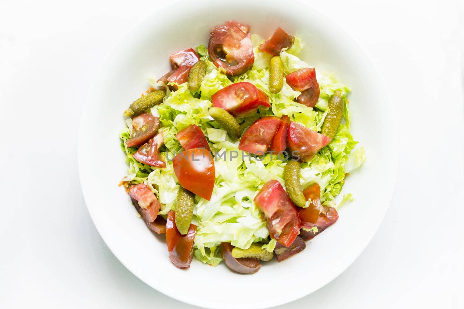 Lettuce salad with tomato and pickles. Raw food