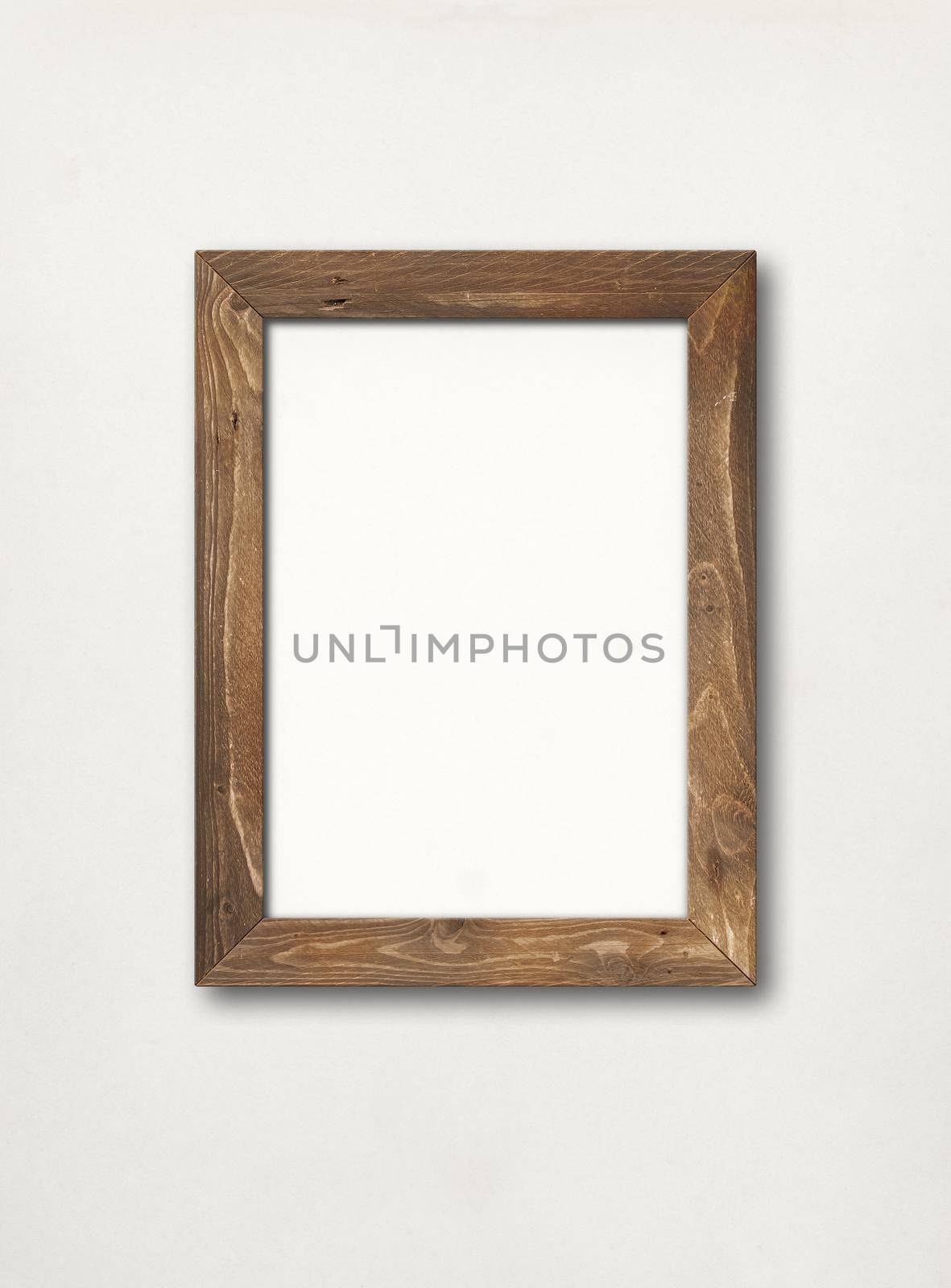 Old brown rustic wooden picture frame hanging on a white wall. Blank mockup template