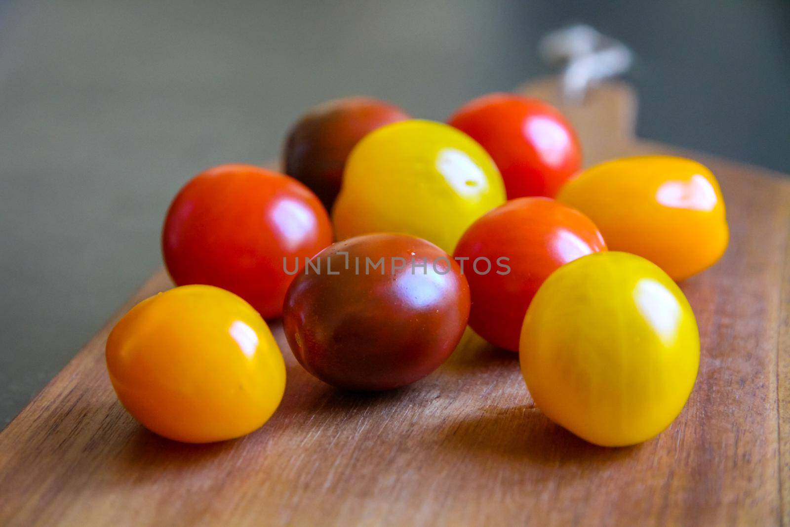 Colorful cocktail tomatoes on a wooden cutting board