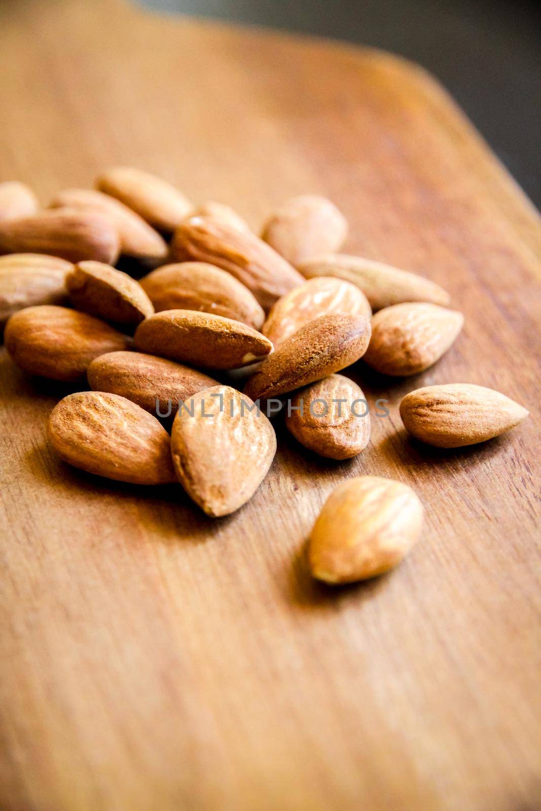 Almonds on a wooden cutting board by daboost