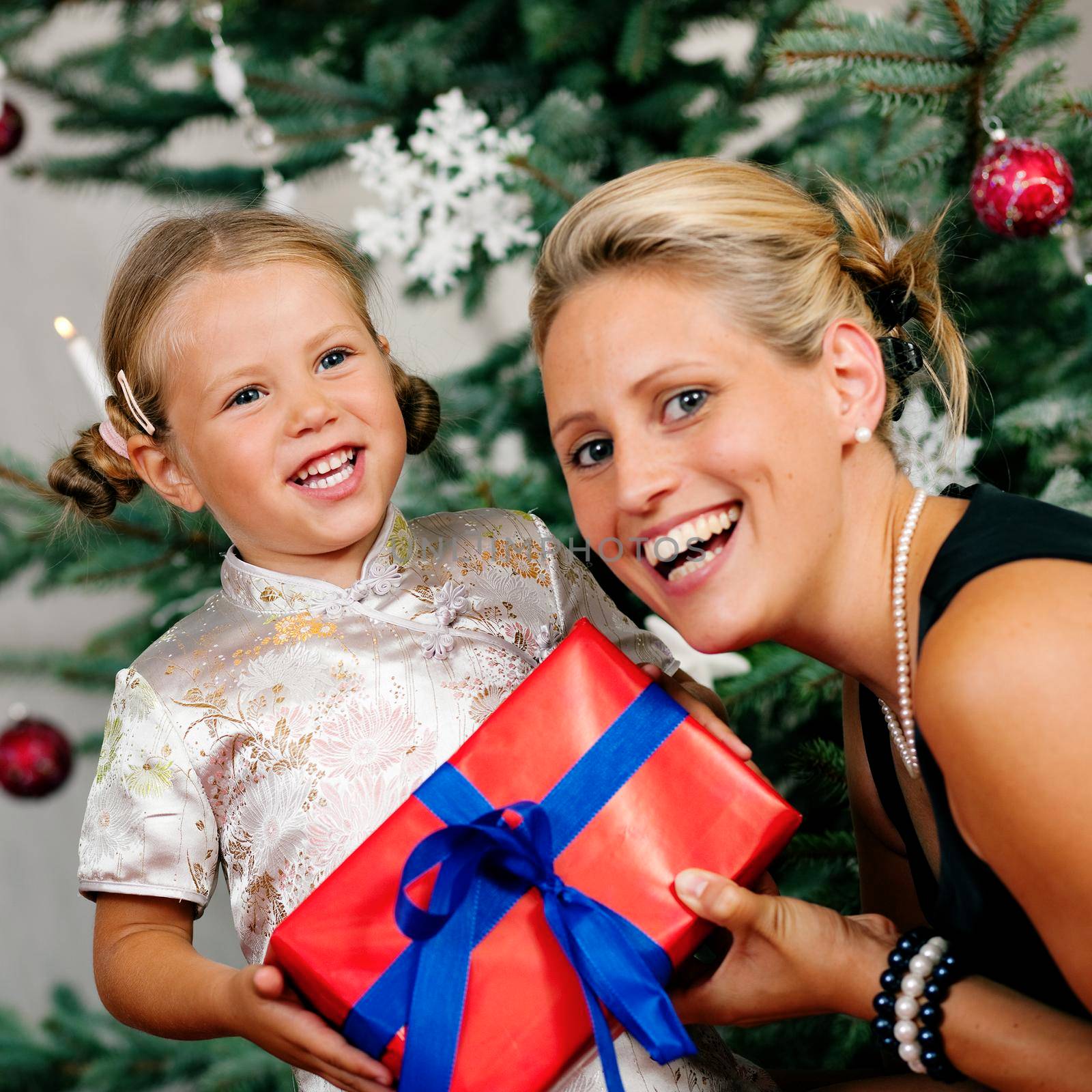 Young girl receives a gift by her mother