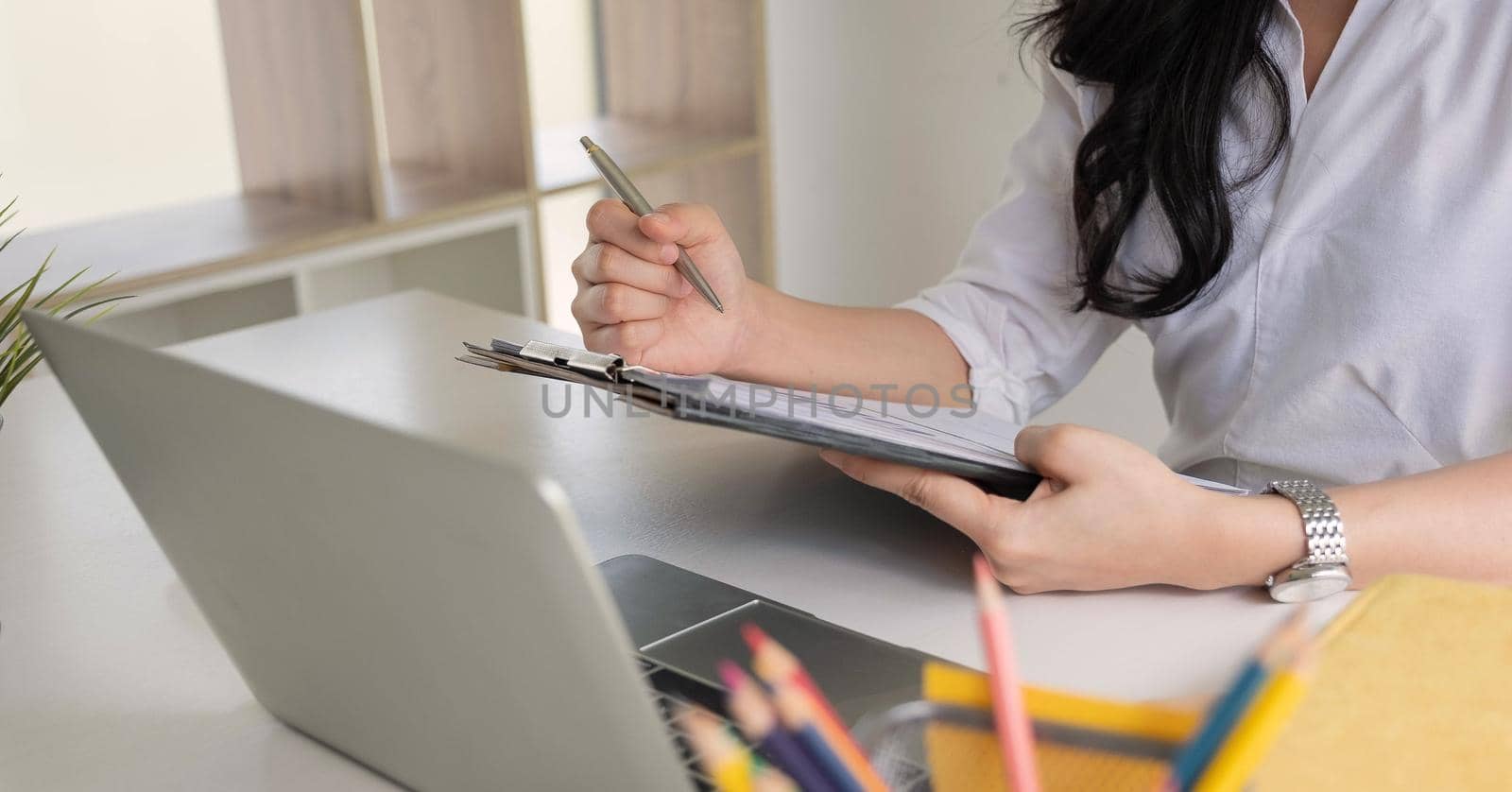 Businesswoman working analysis financial report clipped to pad at workplace closeup by nateemee