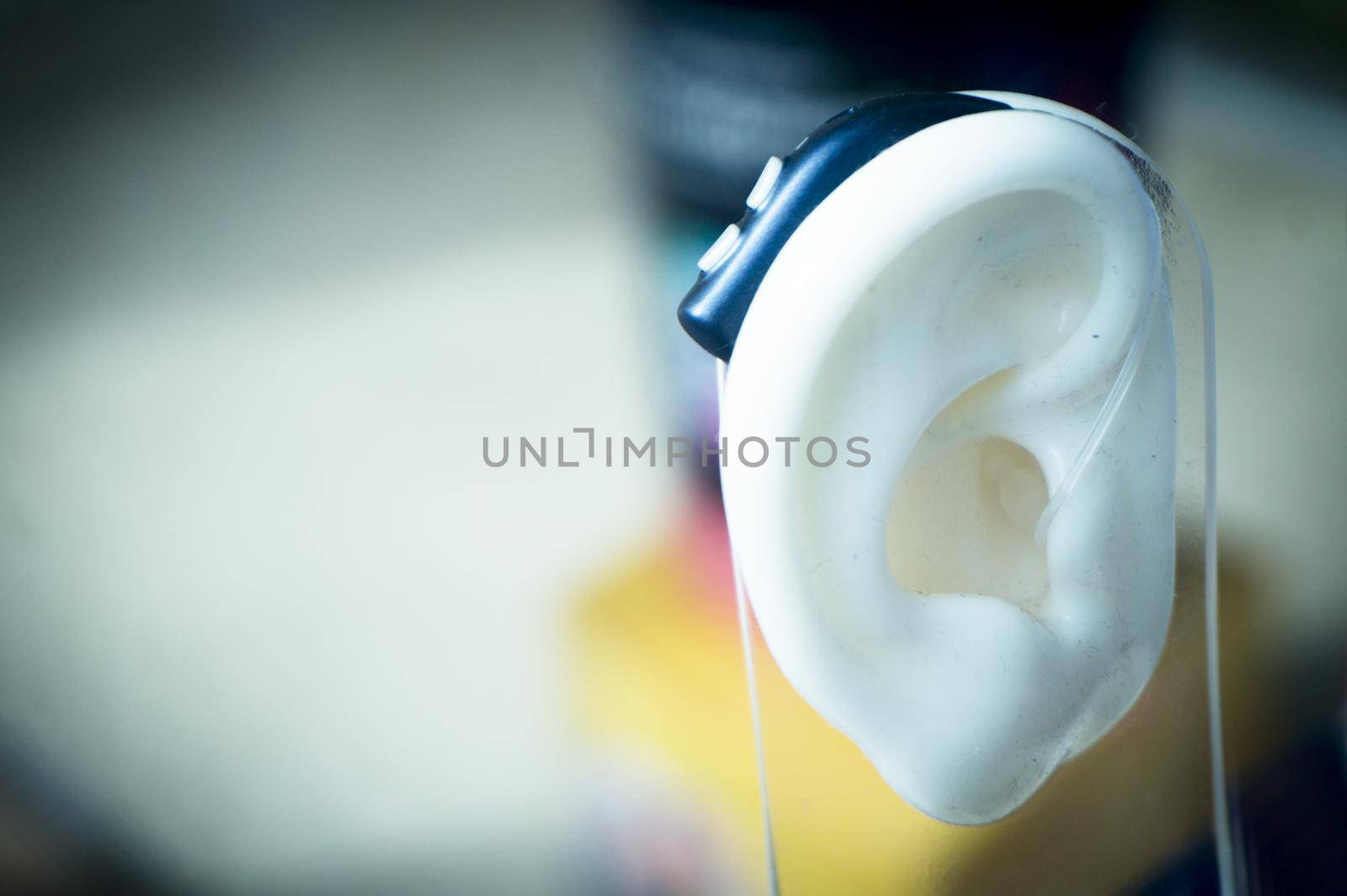 Plastic ear with modern hearing aid. No people