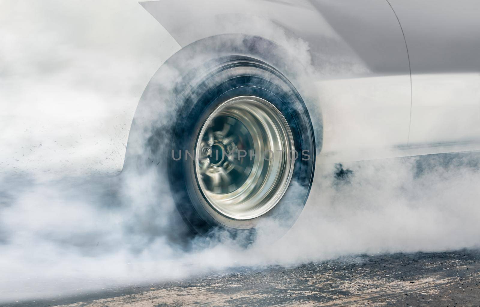 Drag racing car burns rubber off its tires in preparation for the race