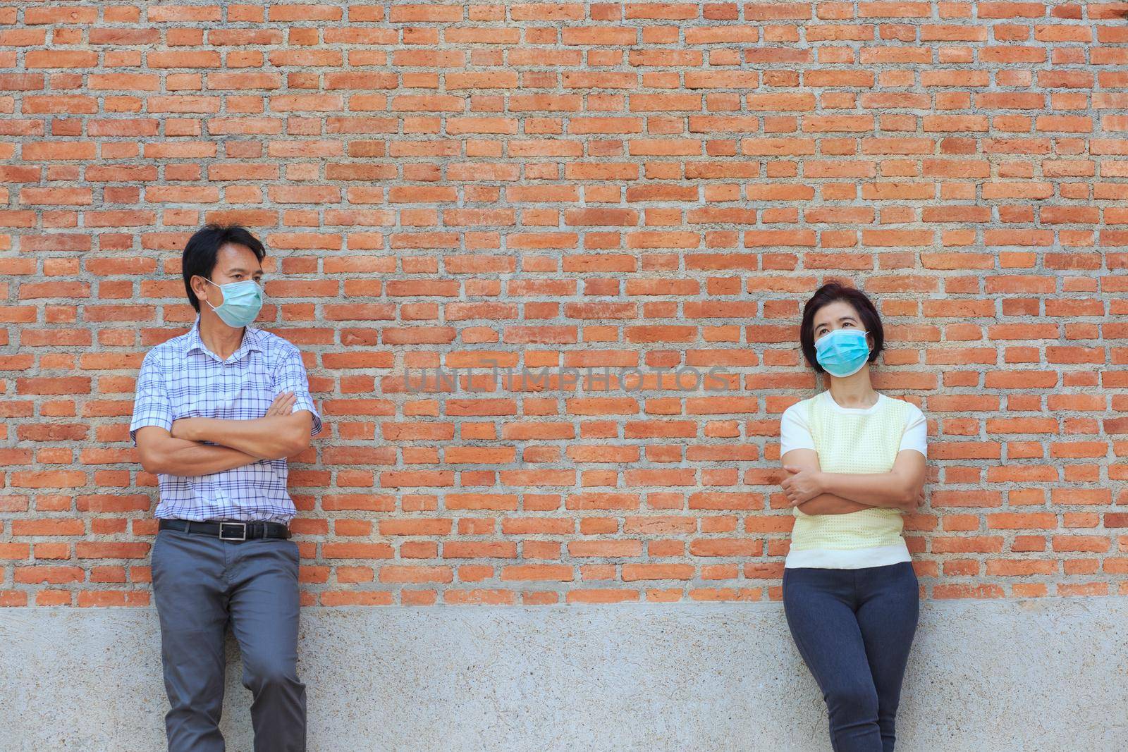 Asian middle aged people wearing mask and keep social distancing to avoid the spread of COVID-19 by toa55