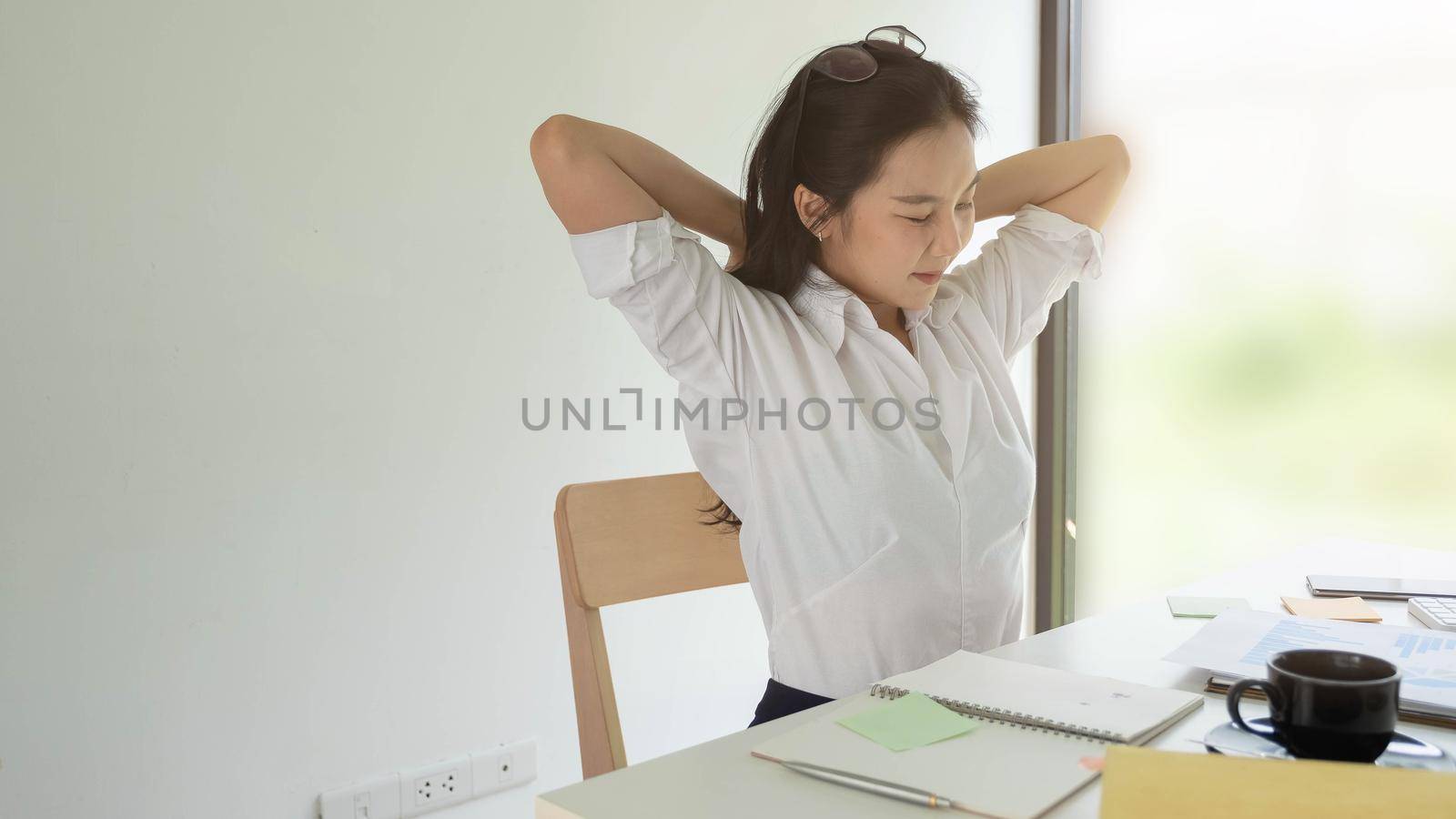 Businesswoman relaxing at comfortable in office hands behind head, happy woman resting in office satisfied after work by nateemee