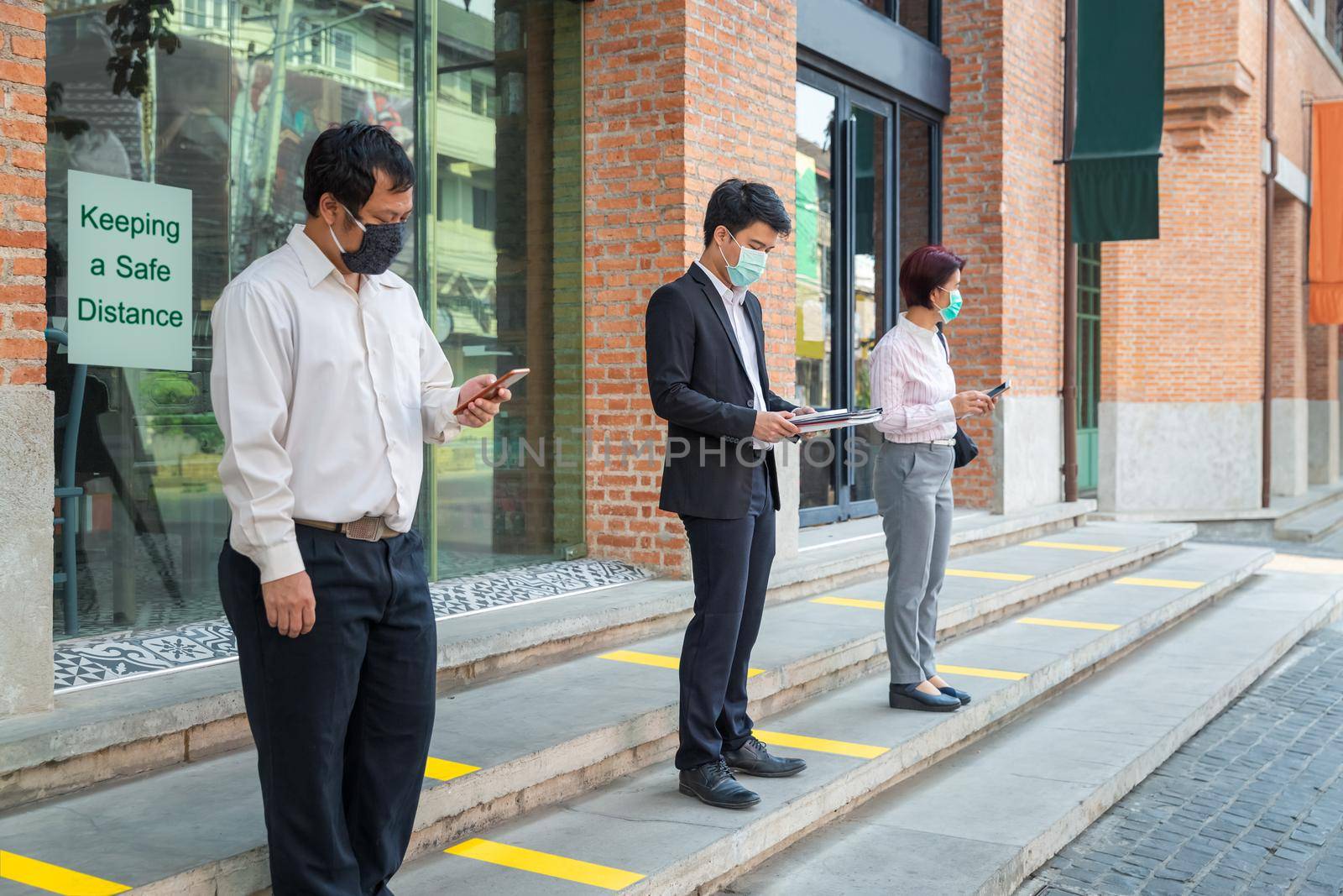 Asian middle aged people wearing mask and keep social distancing to avoid the spread of COVID-19