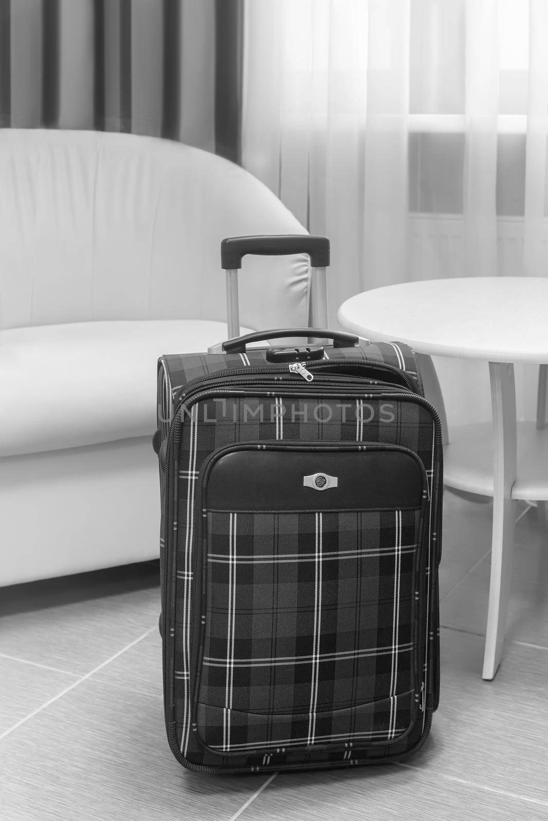 Traveler's suitcase in a cozy hotel room by georgina198