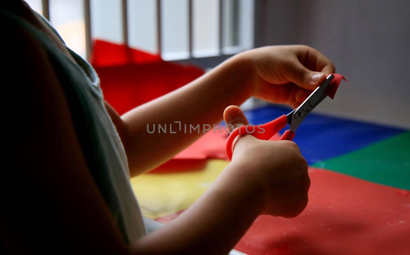 salvador, bahia / brazil - may 18, 2020: child is seen using scissors to cut paper during school assignment.
