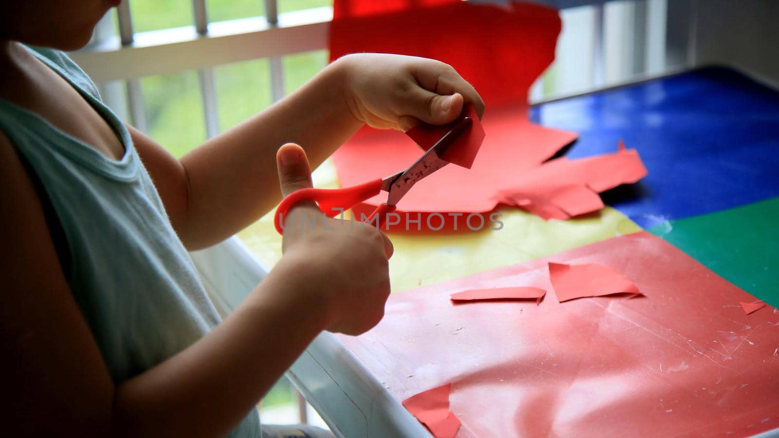 child cutting paper with scissors by joasouza