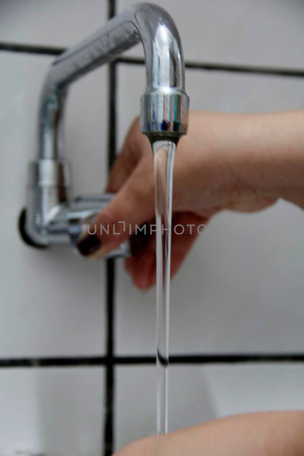 salvador, bahia / brazil - april 26, 2013: person washing hands in kitchen sink in the city of Salvador.




