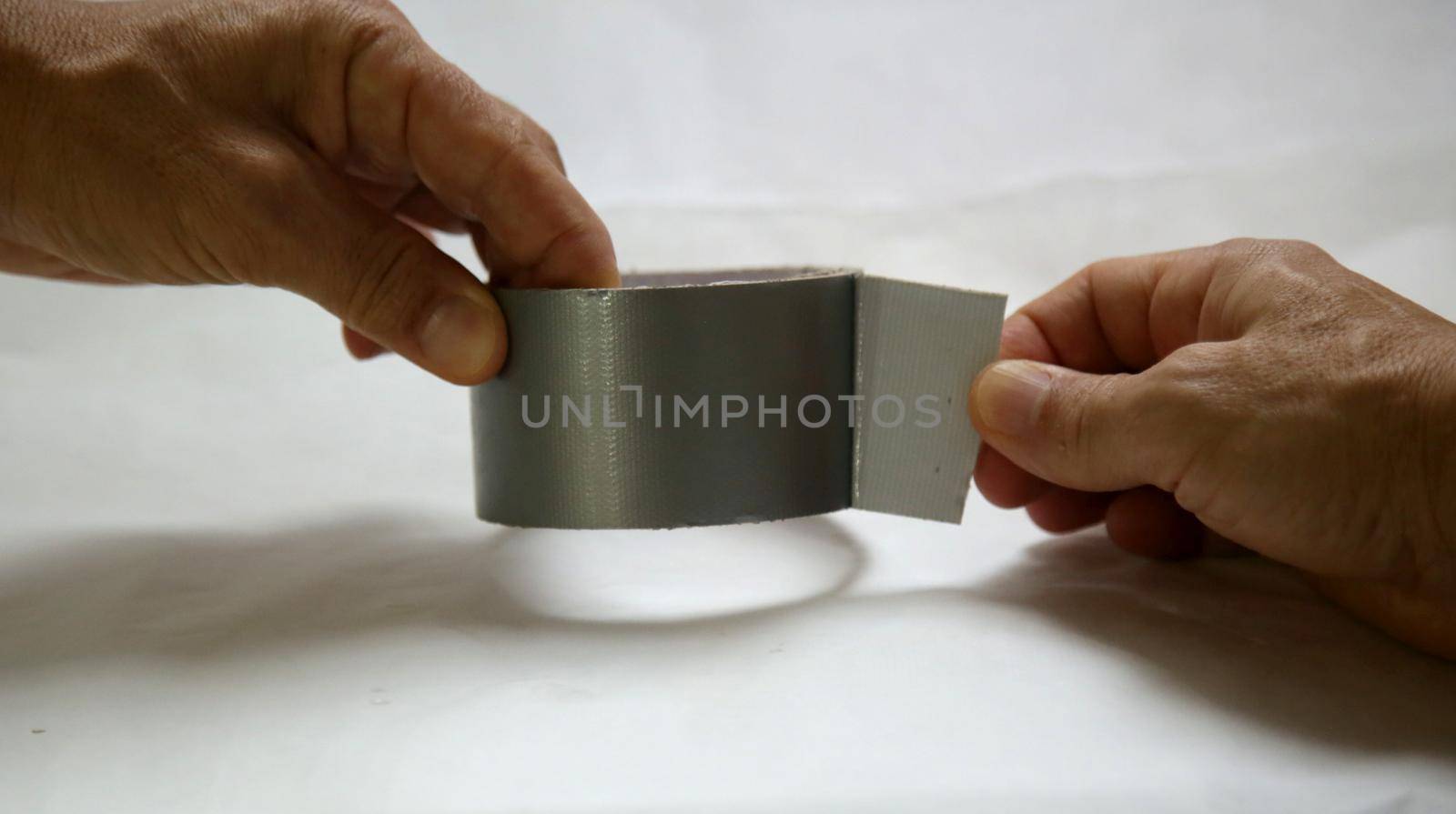 salvador, bahia / brazil - may 24, 2020: hand opening adhesive tape on a roll.
