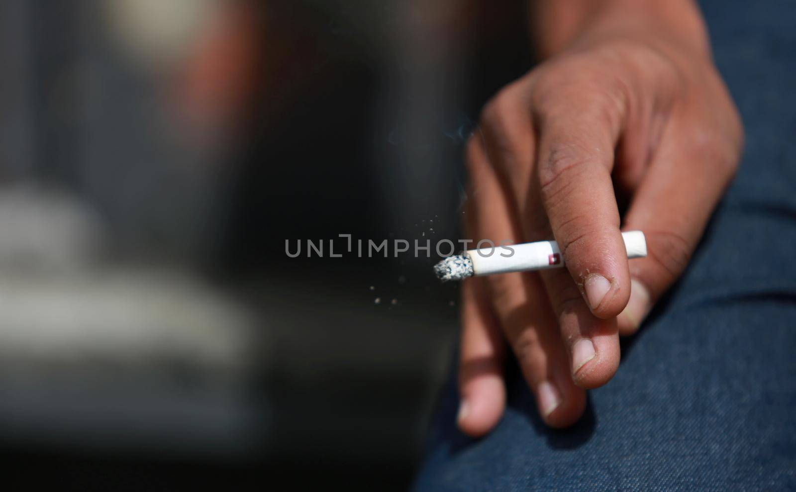 salvador, bahia / brazil - May 29, 2015: Young man is seen smoking a cigarette in the city of Salvador.