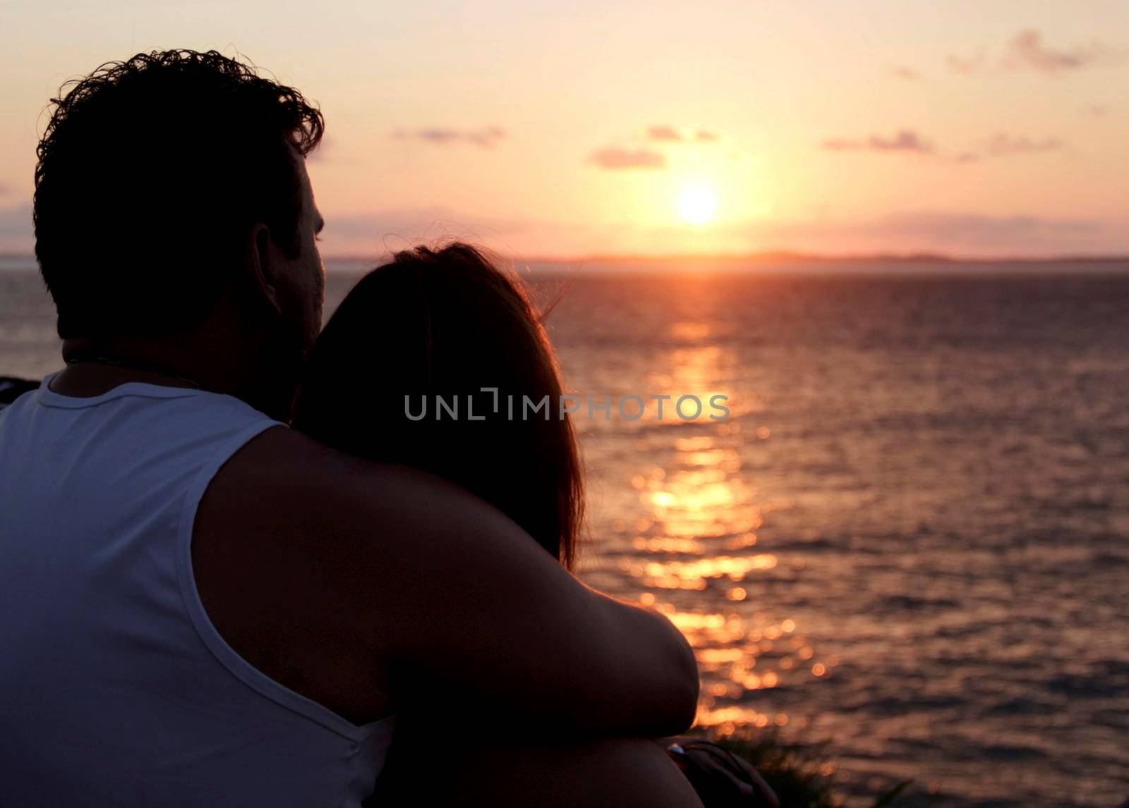 salvador, bahia / brazil - august 30, 2014: couple watching the sunset at Baia de Todos os Santos in the city of Salvador.