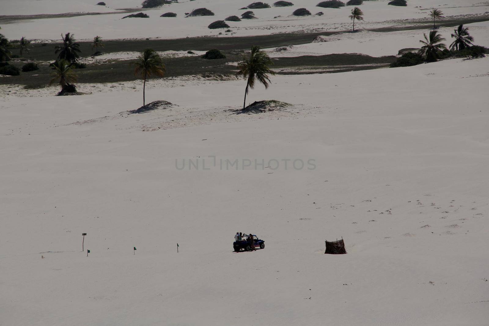 jandaira, bahia / brazil - december 24, 2013: buggy vehicle is seen passing by tourists through the sand dunes of Mangue-Seco, in the municipality of Jandaira.