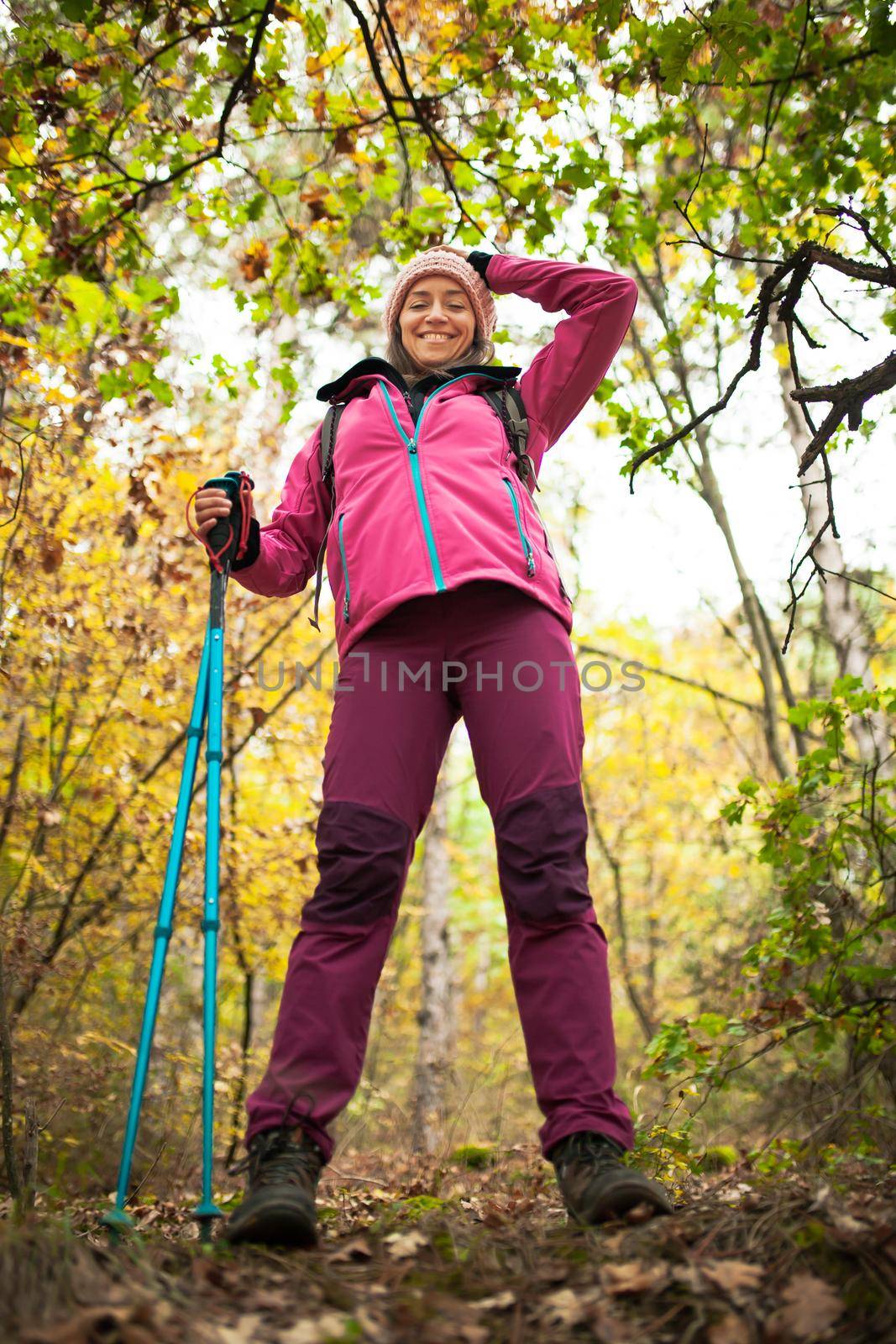 Hiking girl in a mountain. Low angle view in a forest. Healthy fitness lifestyle outdoors.