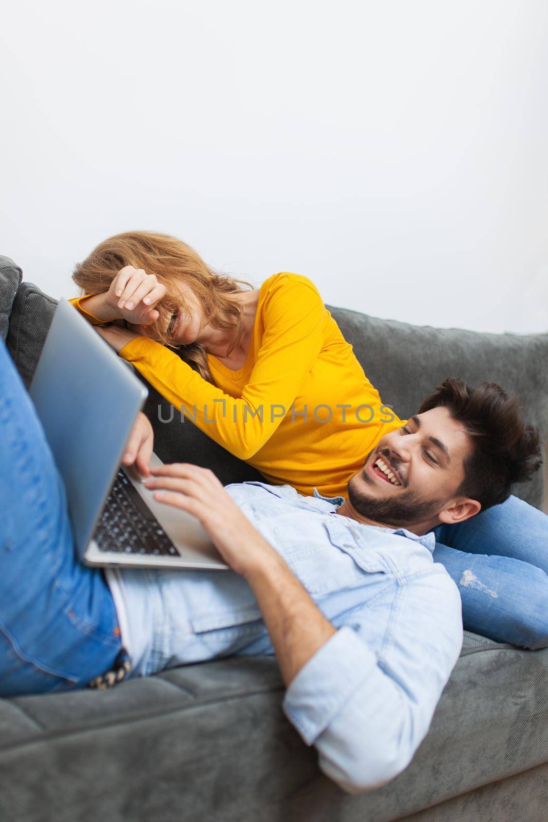 boy lying with laptop on girlfriend's lap