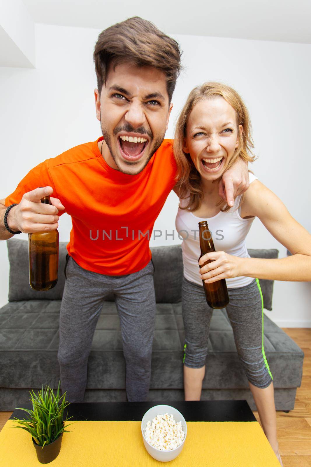 couple with beer bottles cheering and screaming