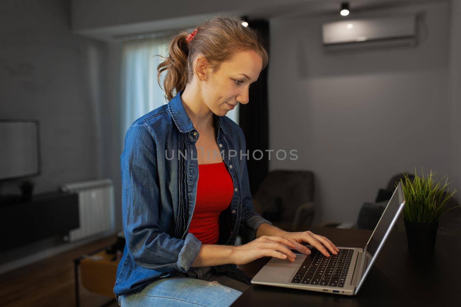 Girl working on a laptop at home by kokimk