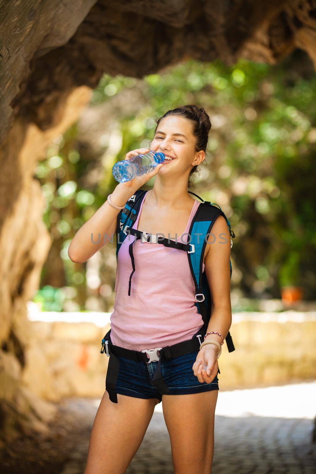 young and happy hiker girl drinking water by kokimk