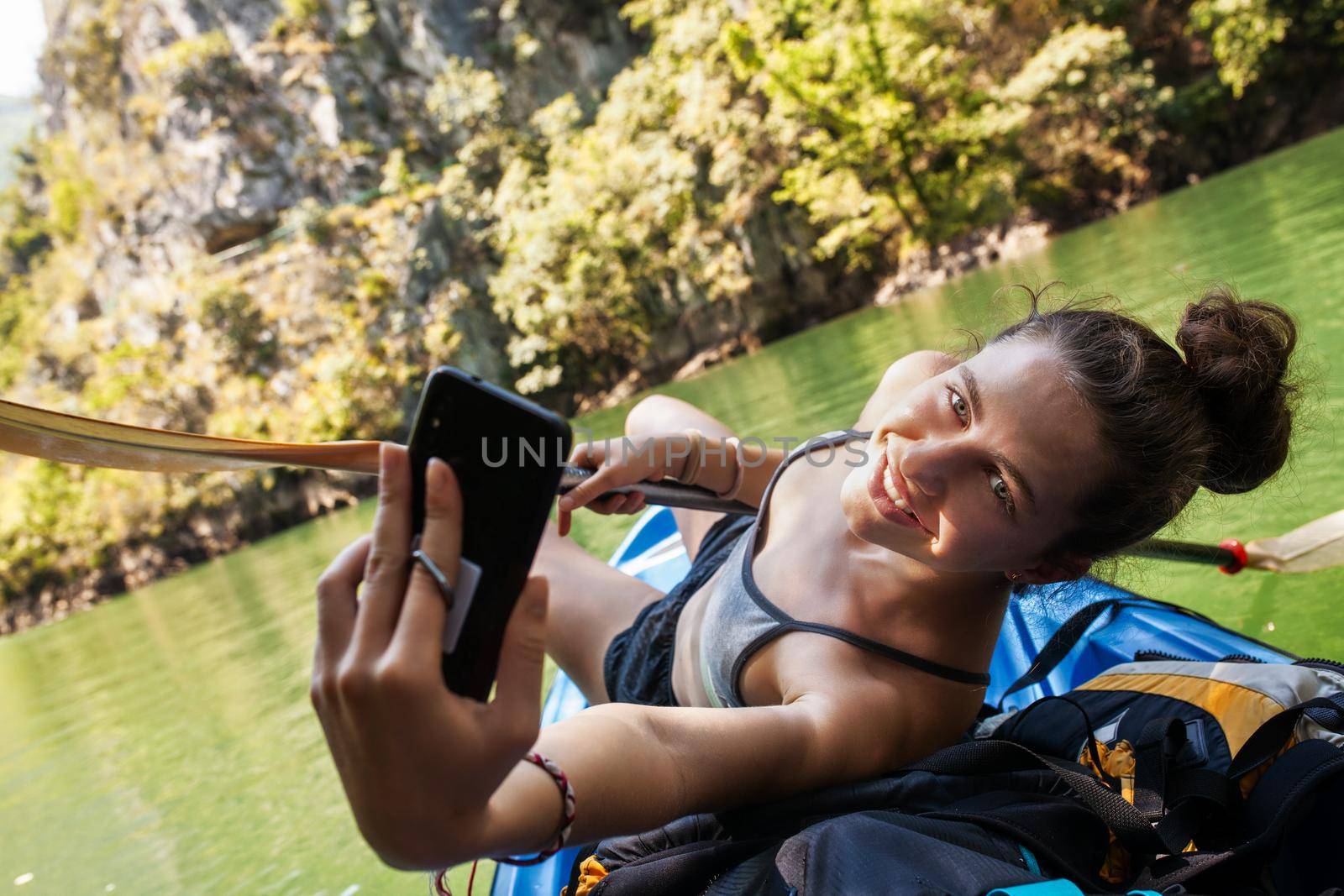 young beautiful girl taking a selfy on a kayak ride