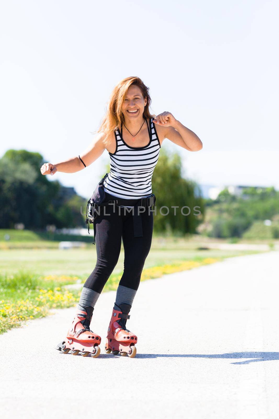 roller skating girl on asphalt road outdoors on a hot summer day by kokimk