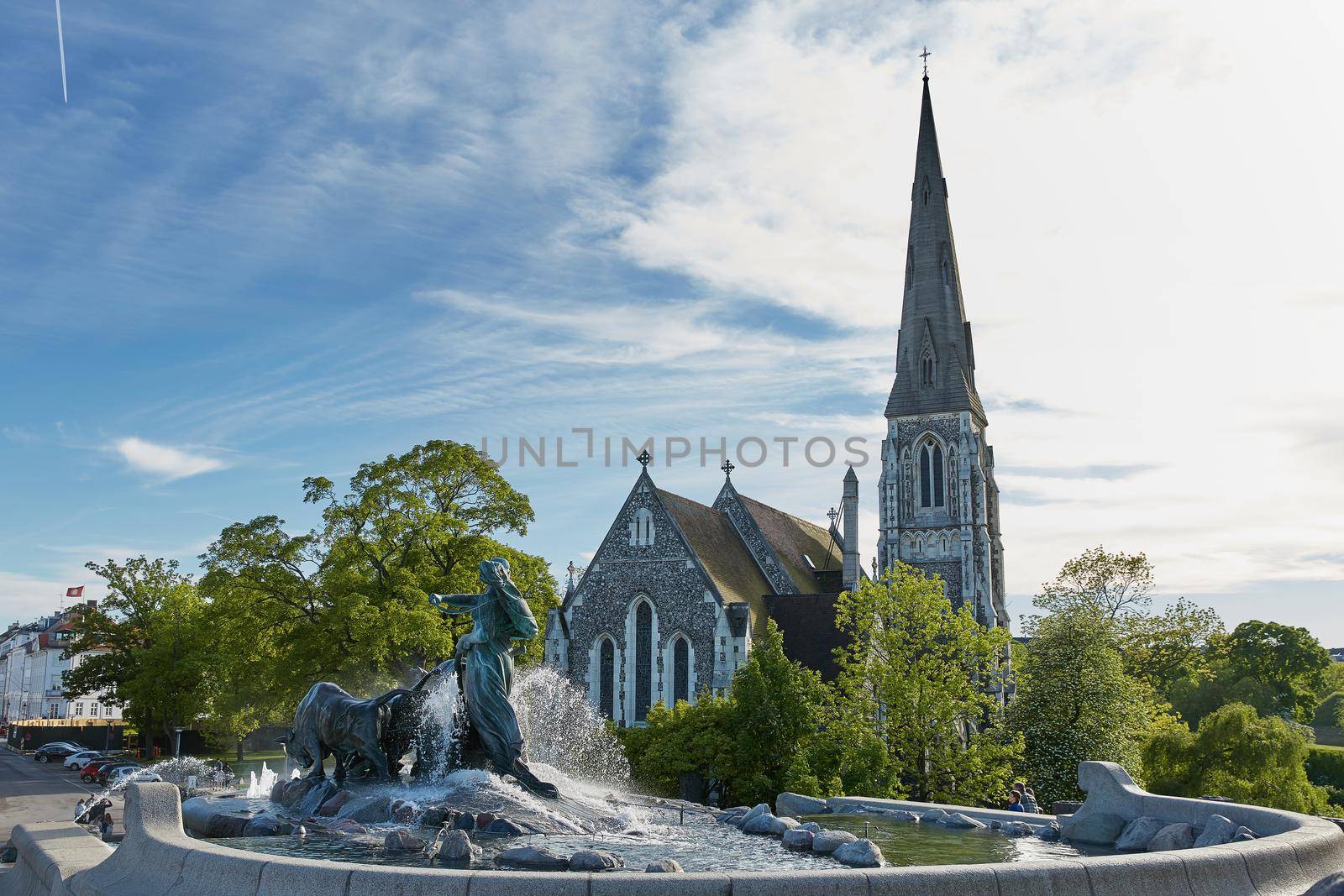 COPENHAGEN, DENMARK - MAY 25, 2017: The Gefion Fountain (Danish: Gefionspringvandet) on the harbor front. It features oxen being driven by the Norse goddess Gefjon. St Alban's Church in the background.