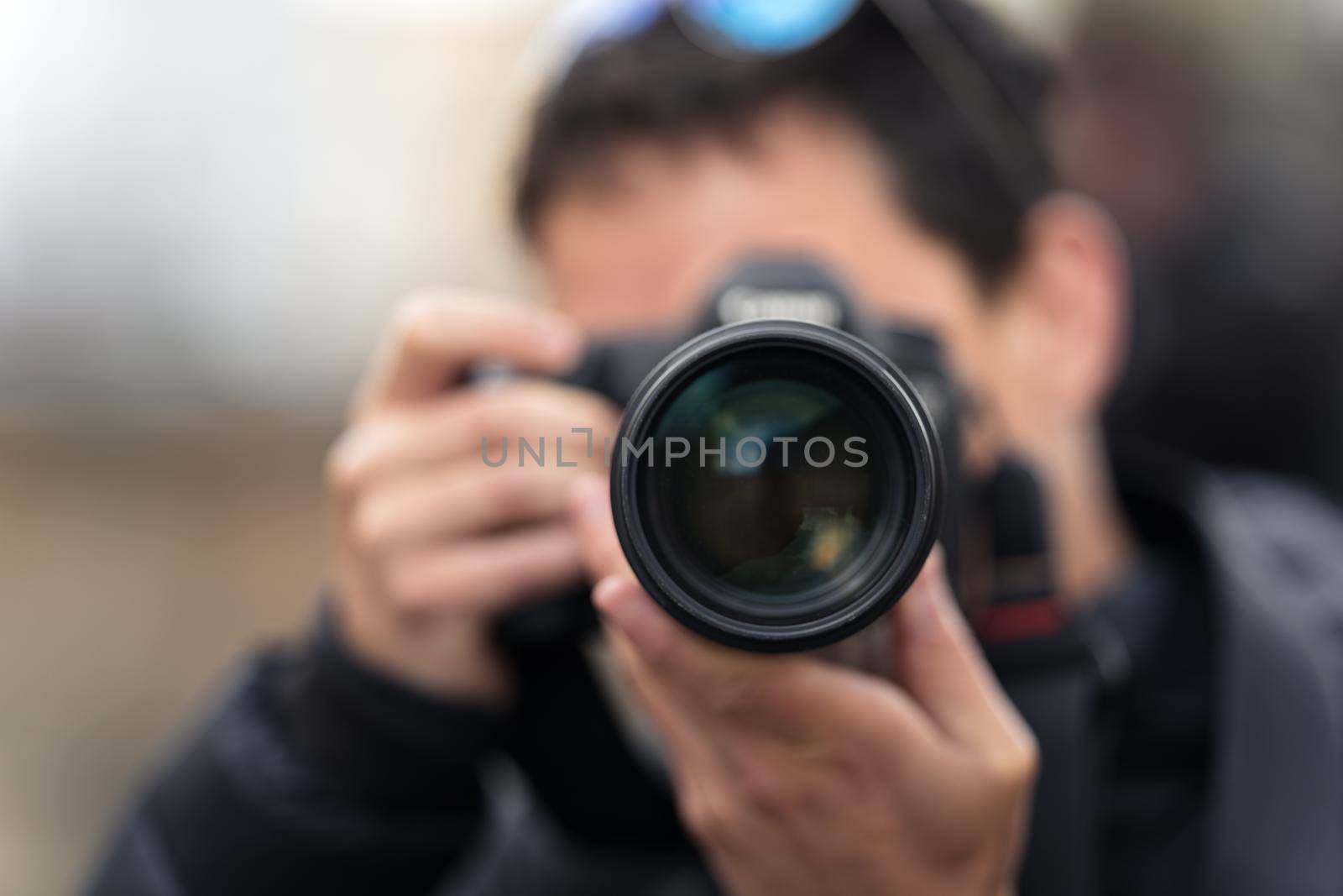 photographer reporter taking a photo, close up of the lens.