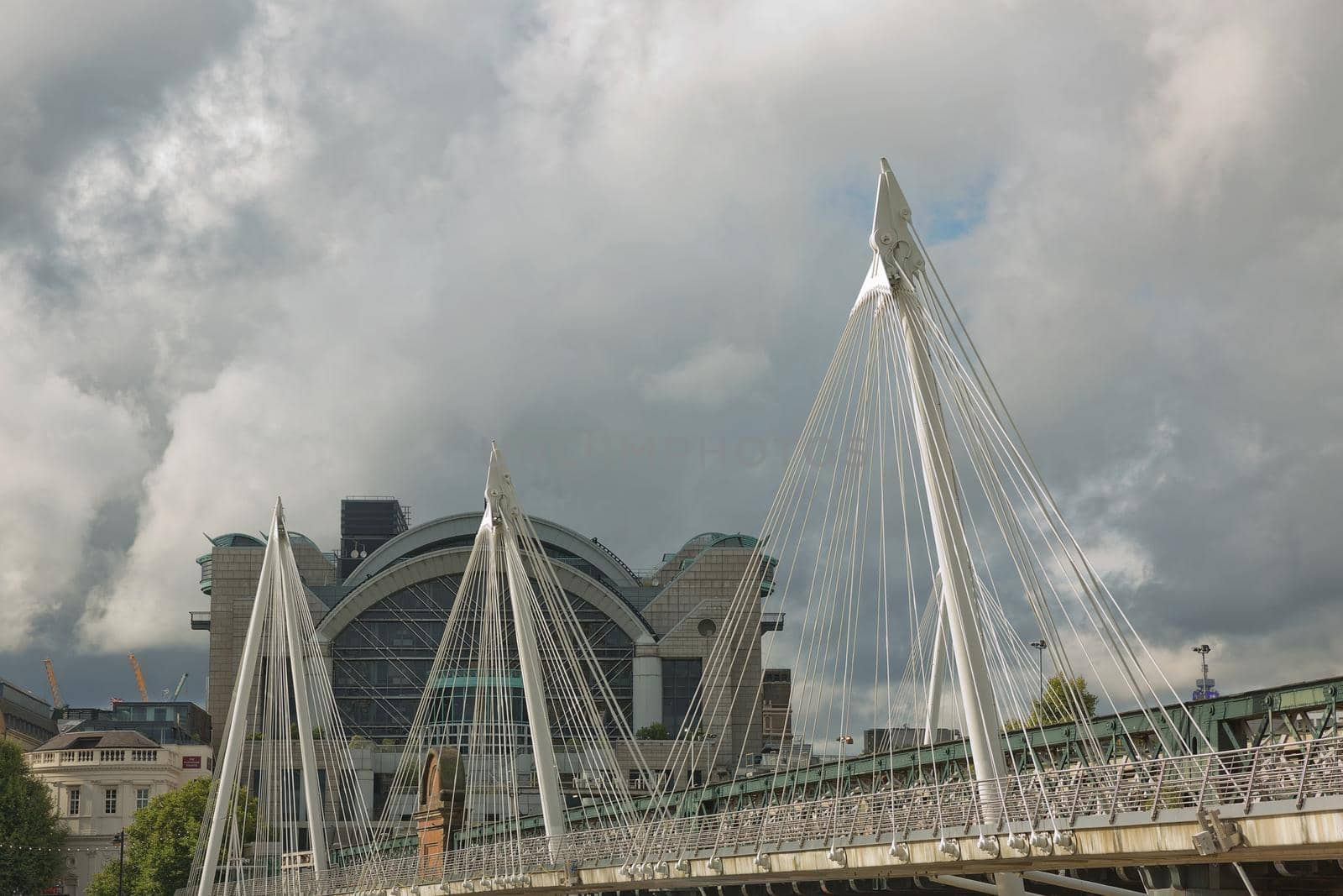 LONDON, UK - SEPTEMBER 08, 2017: View of the Golden Jubilee Bridges and Charing Cross Station from the South Shore of the River Thames in London on a cloudy Summer day.