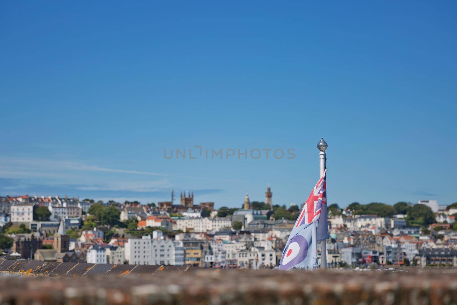 View of a flag and St. Peter Port from Castle Cornet in St Peter Port, Guernsey, UK by wondry