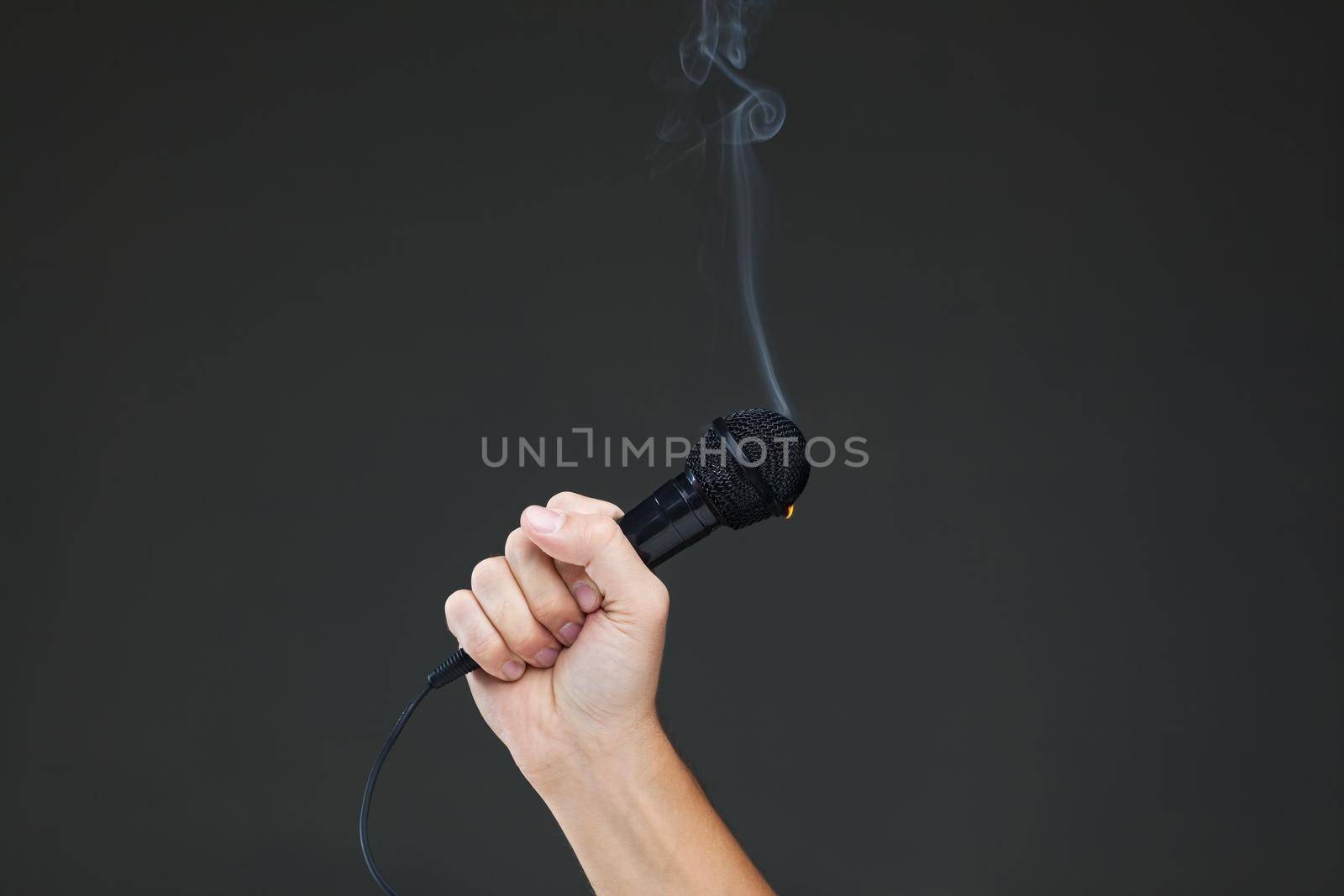 hand holding a smoking microphone