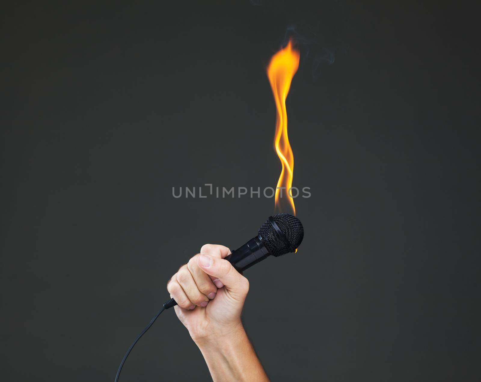 hand holding a microphone on fire by kokimk