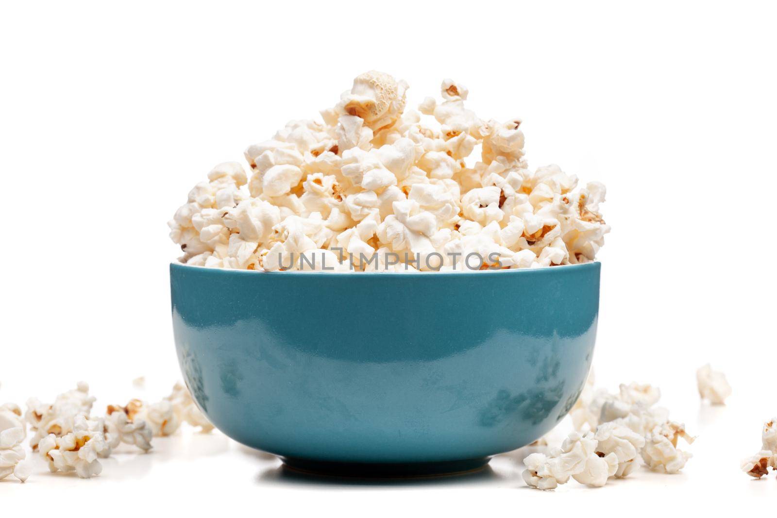 blue bowl with popcorn against white background