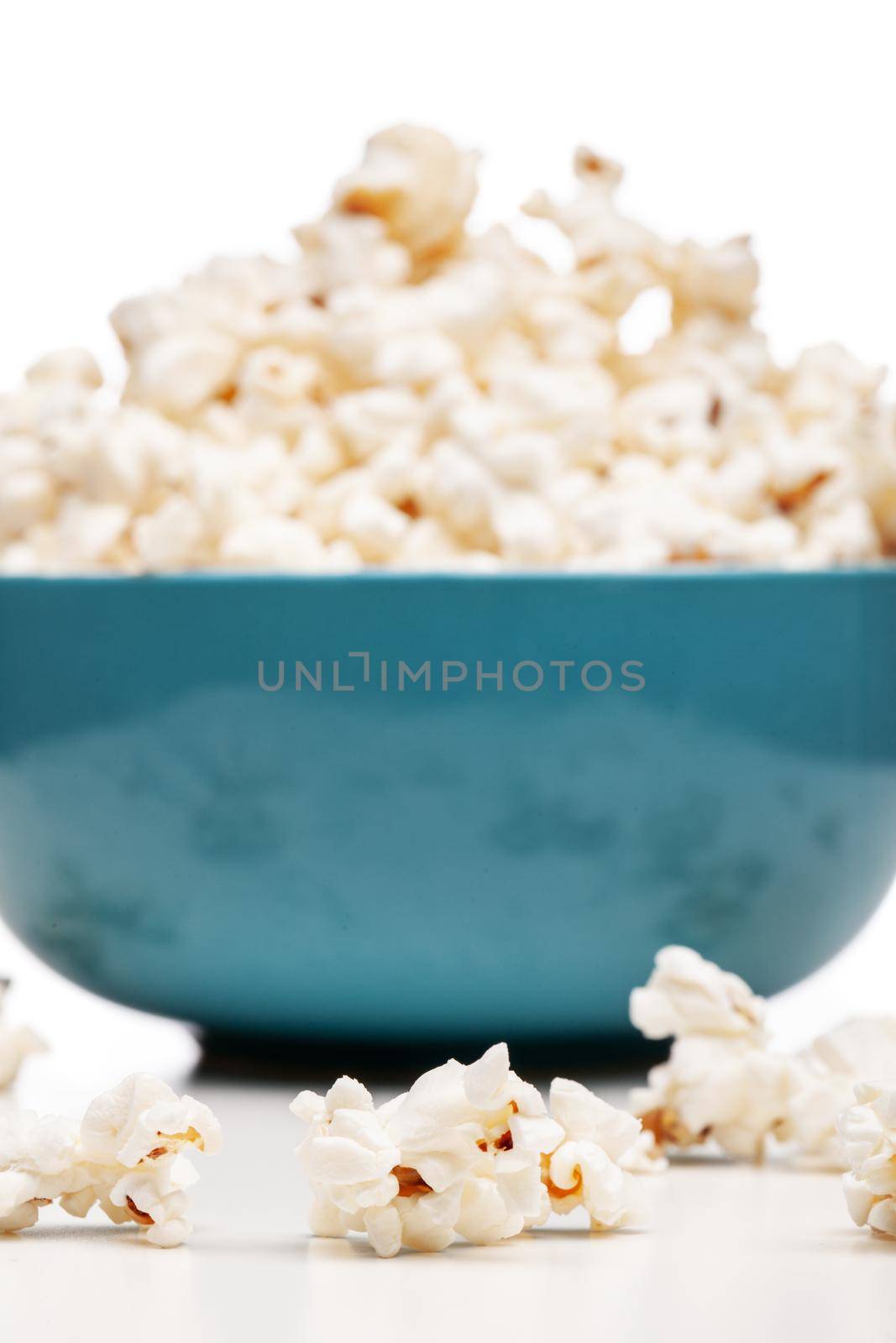 blue bowl with popcorn against white background