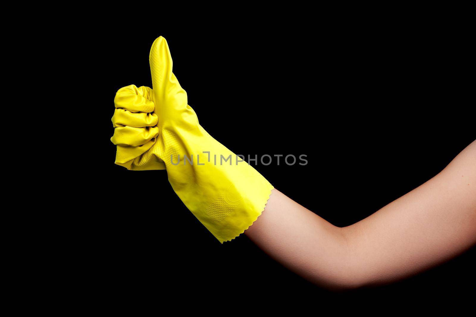 hand in yellow protective glove for cleaning making thumbs up gesture by kokimk