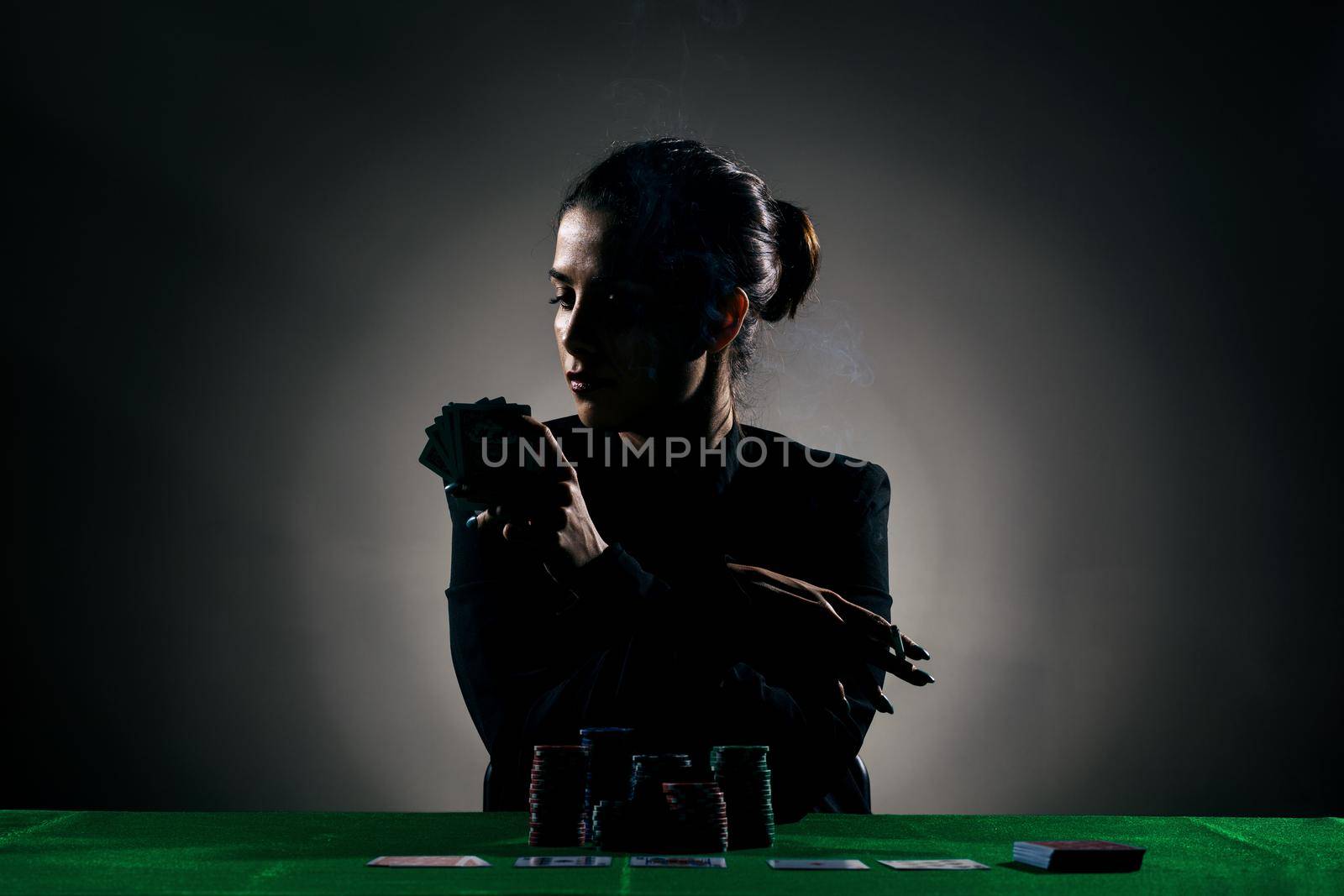 silhouette girl playing poker with lot of chips and holding a cigar