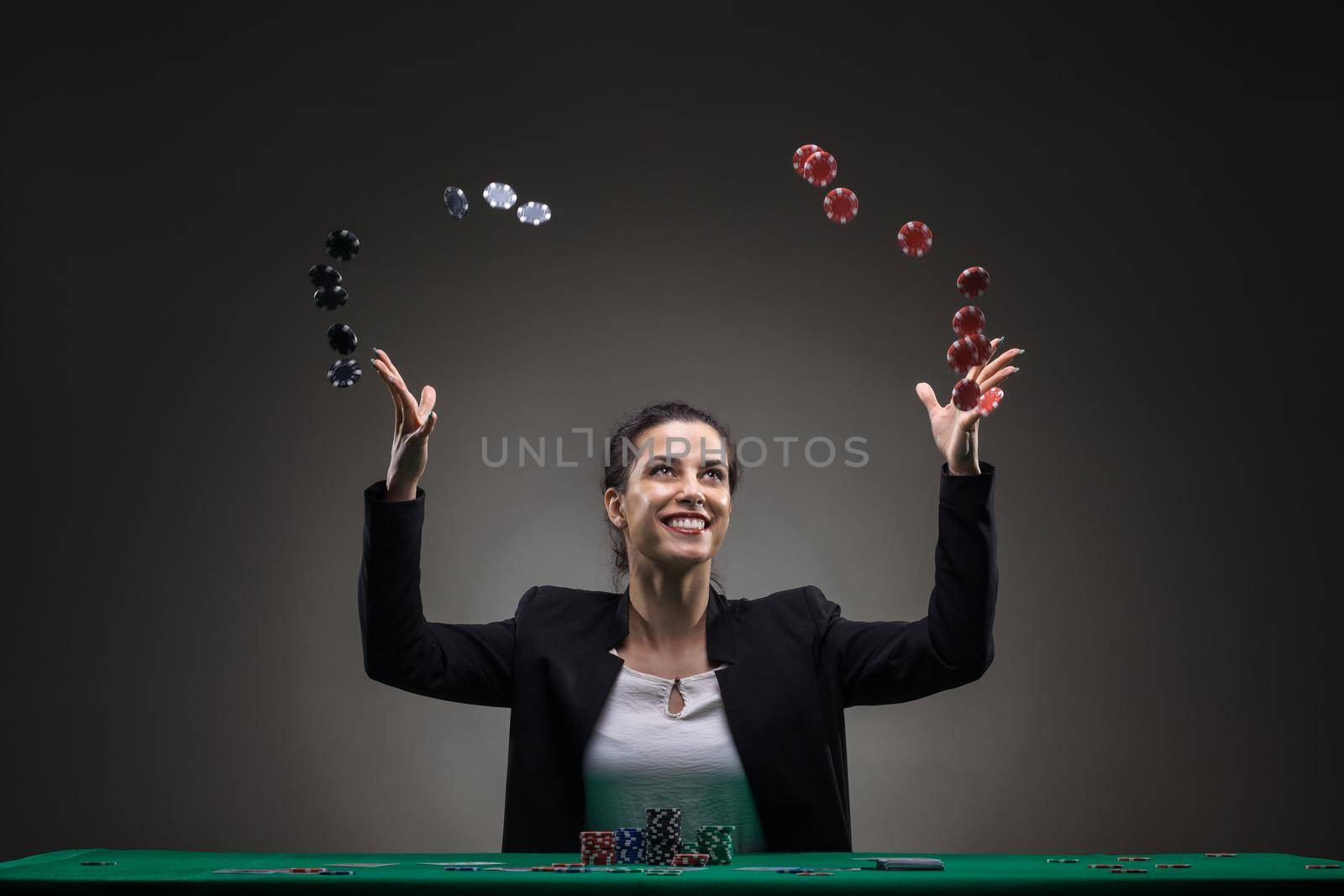 Girl playing poker. Throwing chips in the air.