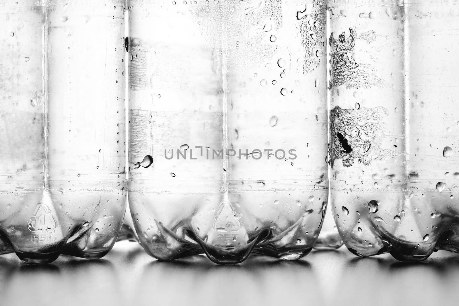 group of empty plastic bottles with condensation droplets