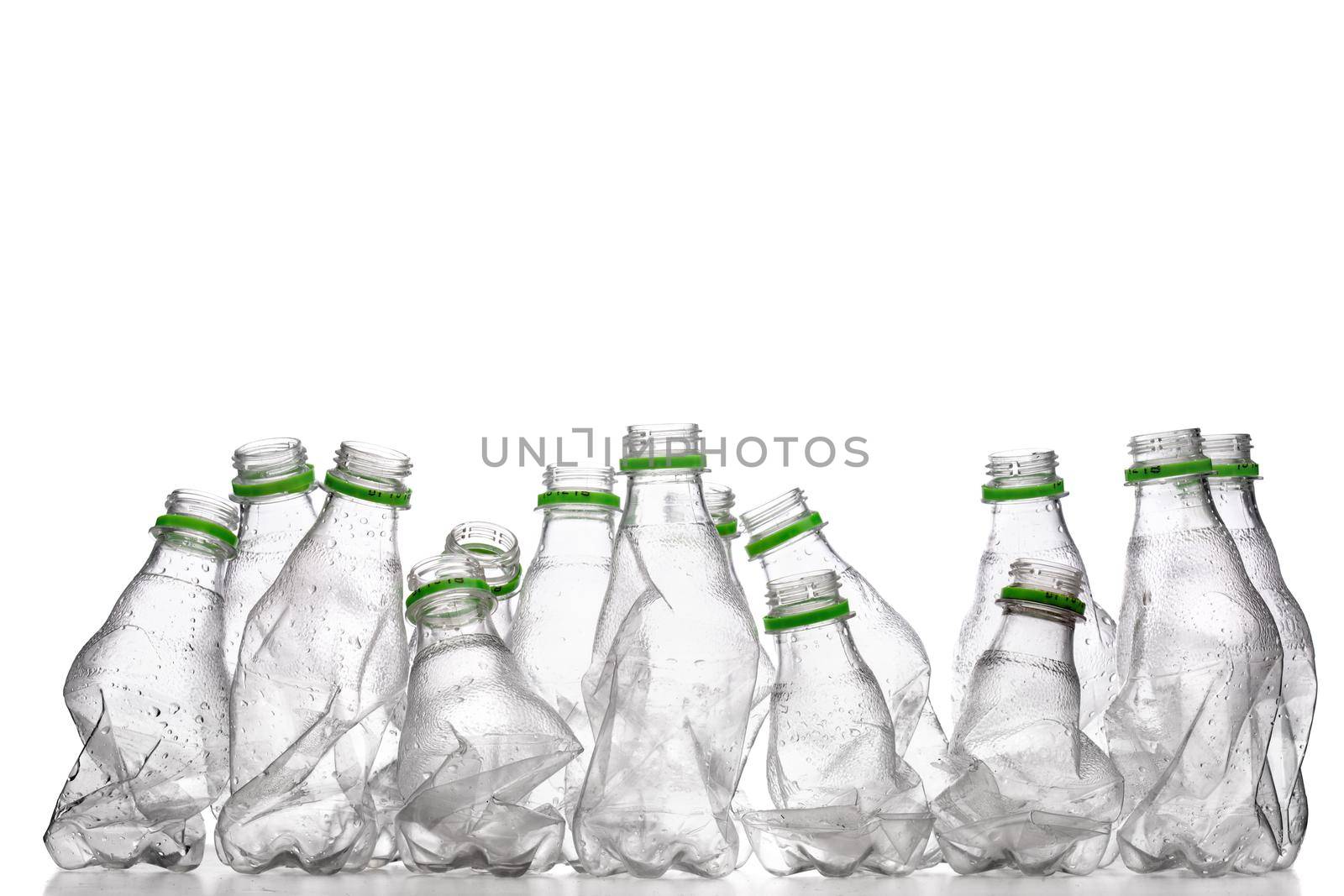 group of smashed empty plastic bottles with green caps, isolated on white background