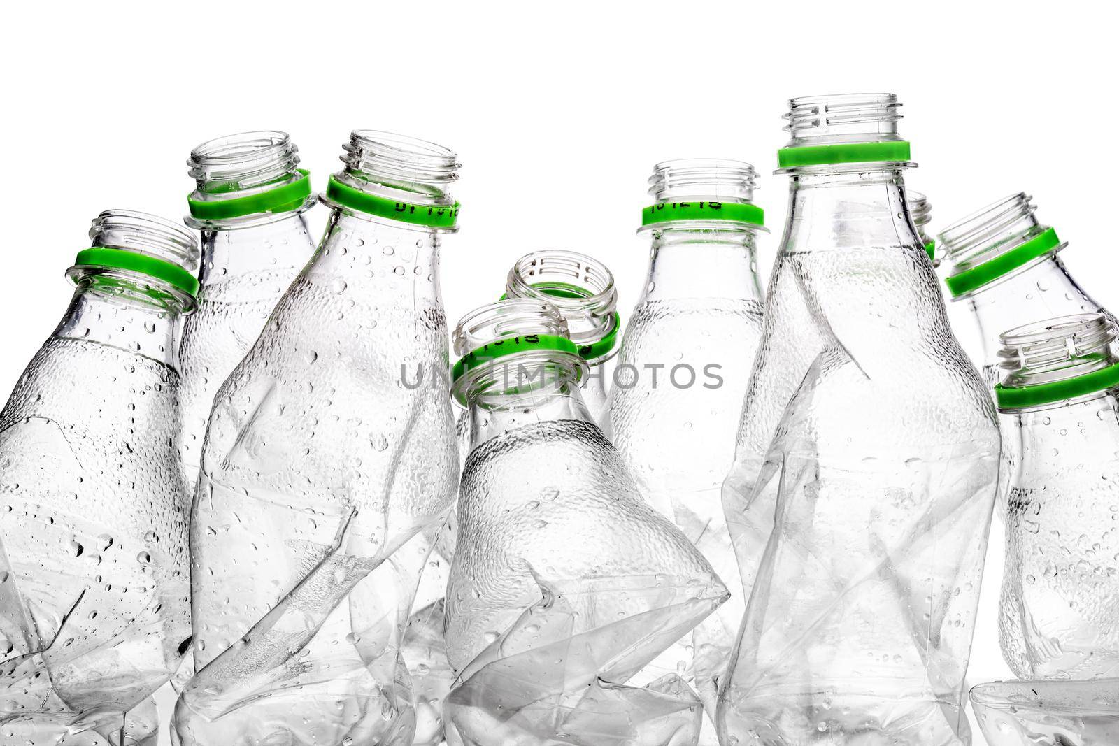 group of smashed empty plastic bottles with green caps, isolated on white background