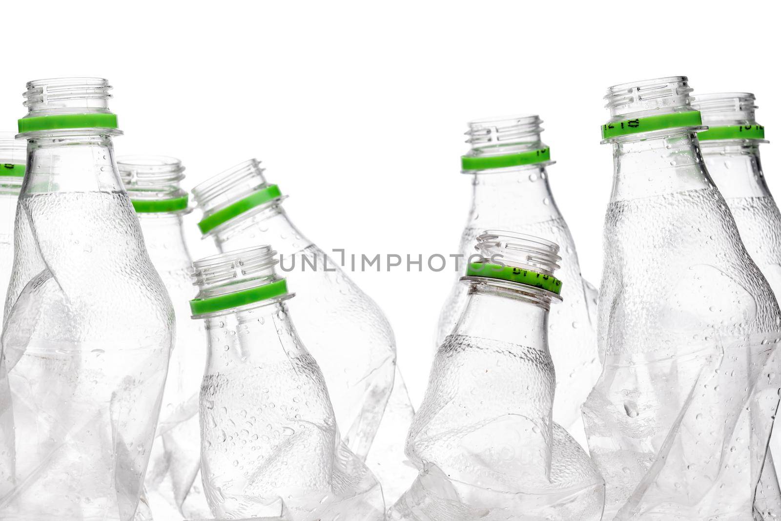 group of smashed empty plastic bottles with green caps, isolated on white background