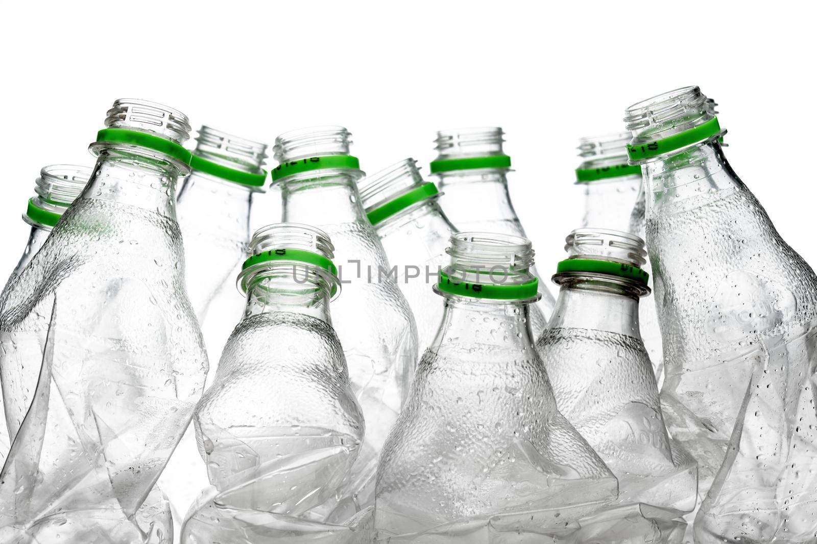 group of smashed empty plastic bottles with green caps, isolated on white background